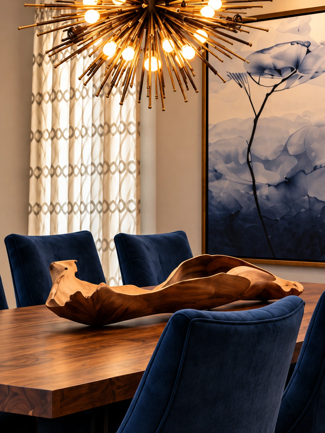 Starburst chandelier, navy dining chairs and sculptural wood centerpiece at Del Mar Residence